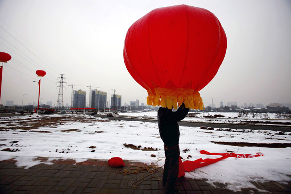 15 November 2009: Luoyang, China: A worker installs lanterns