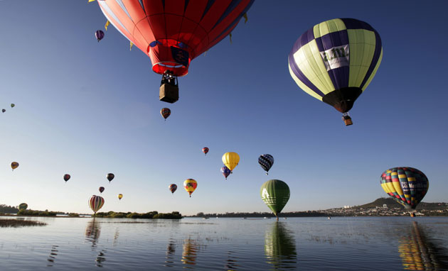 15 November 2009: Leon, Mexico: Hot air balloons fly over a lake