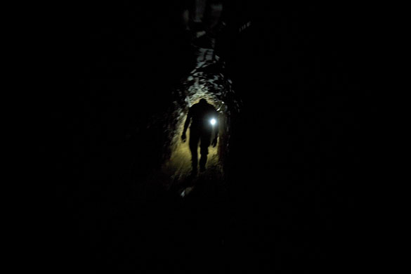 24 hours in pictures: A Palestinian smuggler walks inside a tunnel from Egypt to the Gaza Strip