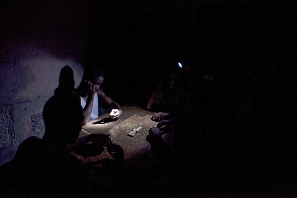 24 hours in pictures: People play dominoes lit by a torchlight in Port-au-Prince, Haiti