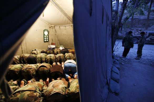 24 hours in pictures: Afghan National Army soldiers pray in a  French military tent