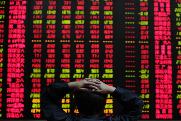 Week in Business: A woman reads stock information at a brokerage house in Shanghai