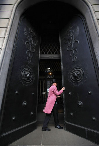 Week in Business: A doorman opens a door at the Bank of England in London