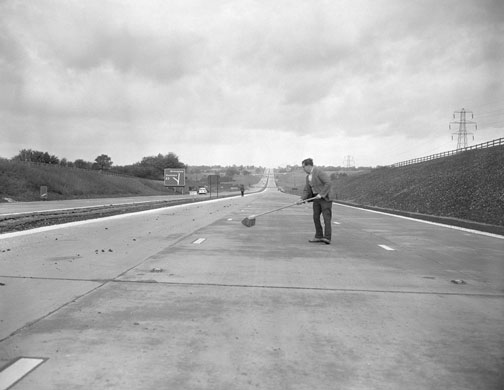 M1 motorway: 1959: A workman sweeps part of the new London-Yorkshire motorway
