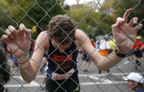 24sport: A runner rests his hands on a fence