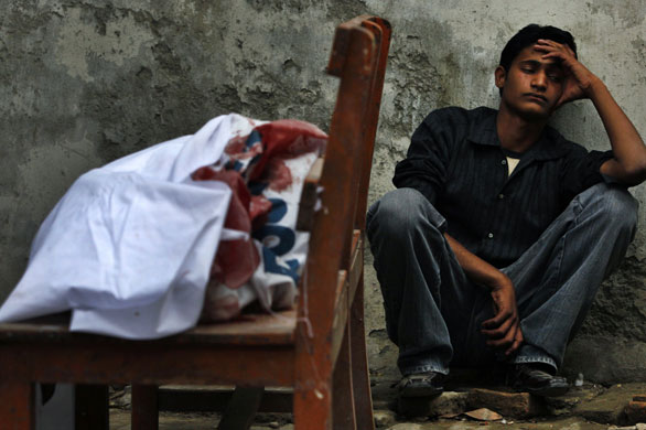 24 hours in pictures: A man with the body of his brother killed in a bomb blast in Rawalpindi 