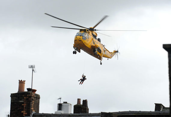Weather flooding: An ARAF Sea King rescue helicopter hovers over Cockermouth in Cumbria