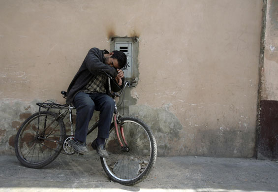24 hours in pictures : A man sleeps on his bike in Lima, Peru