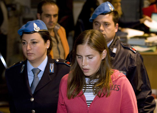 Meredith Kercher trial: Jailed suspect Amanda Knox reacts as she leaves a courtroom