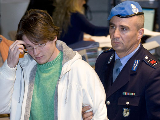 Meredith Kercher trial: Jailed suspect Raffaele Sollecito reacts as he leaves a courtroom