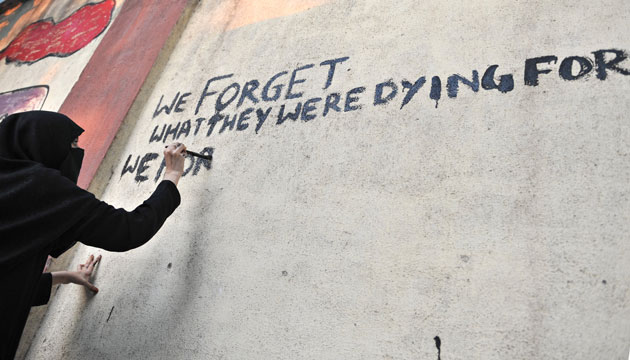 Mumbai attack anniversary: A woman paints a message on a kilometre-long wall