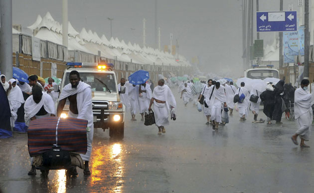 Mecca Hajj: Pilgrims attending the hajj walk on flooded streets during heavy rains