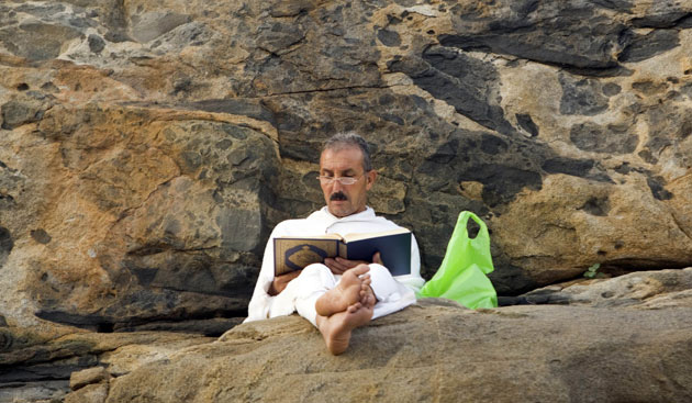 Mecca Hajj: A Muslim pilgrim reads the Koran on Mount Mercy
