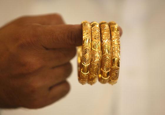 Week in business: A man displays gold bangles at a jewellery shop in Karachi