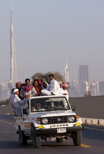 Eid al-Adha: People load-down a vehicle as they pass the Burj Dubai tower