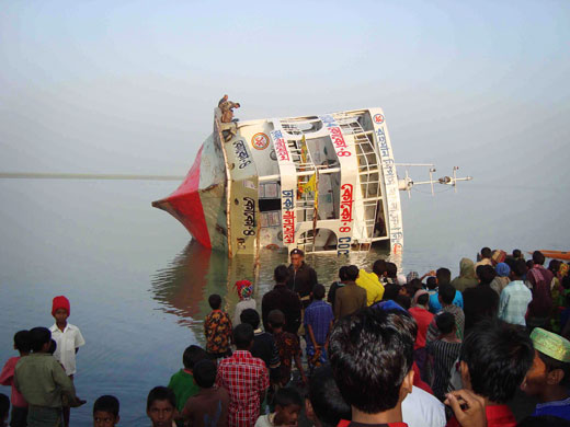 24 Hours in Pictures: Bangladeshi villagers gather at the riverside to inspect a capsized ferry