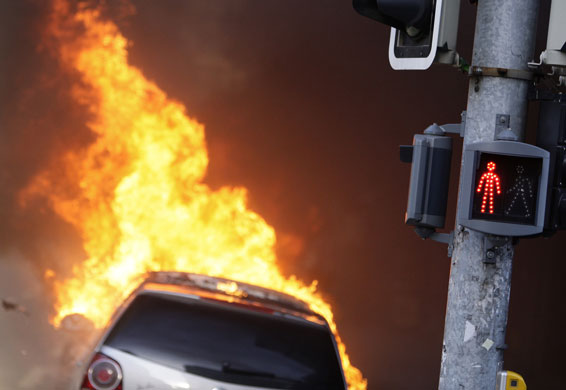 24 hours: A burning car in Geneva during protest against World Trade Organisation 