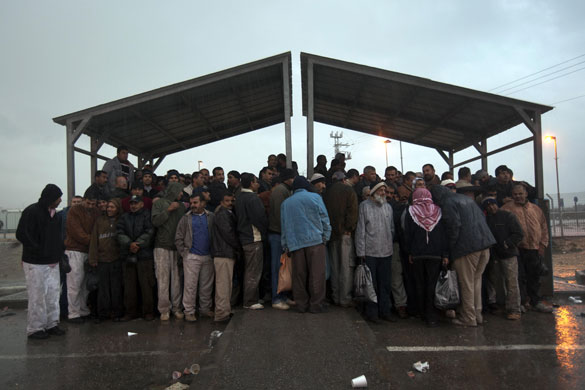 24 hours: Kibbutz Eyal, Israel: Palestinian workers stand under a shelter