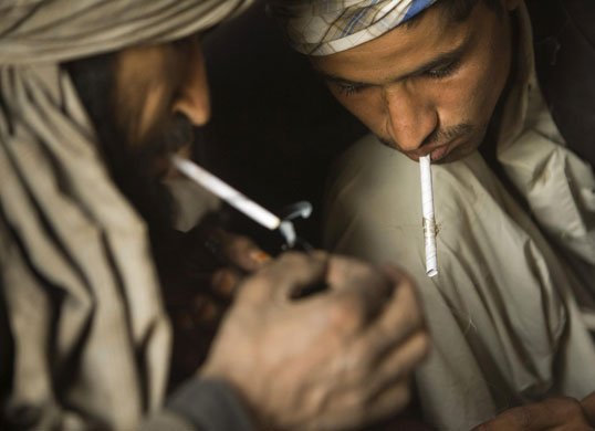 24 hours: Afghans smoke heroin as they sit at a cave