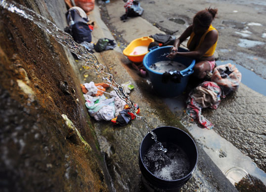 24 hours: Caracas, Venezuela: A woman washes clothes in the street 
