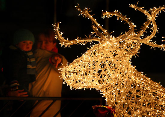 30 November 2009: Glasgow, UK: A mother and child look at a light display of a reindeer