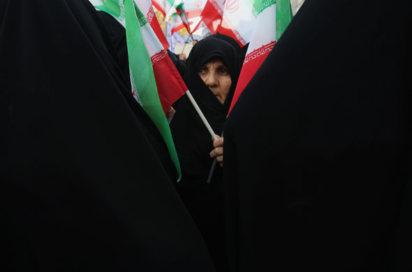 Iran protests: An Iranian woman holds a flag during a rally outside the former US embassy