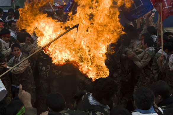 Iran protests: Iranian demonstrators burn US flag outside the former US embassy in Tehran