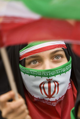 Iran protests: A student waves the Iranian flag during a rally in Tehran