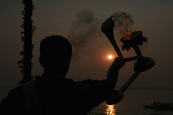 24 hours: Varanasi, India: A Hindu priest on the banks of the River Ganges 