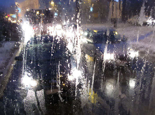 24 hours: Belgrade, Serbia: City lights are reflected in the window of a bus 