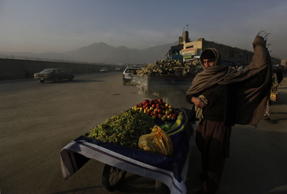 24 hours: Kabul, Afghanistan: A fruit seller wraps himself in a shawl 