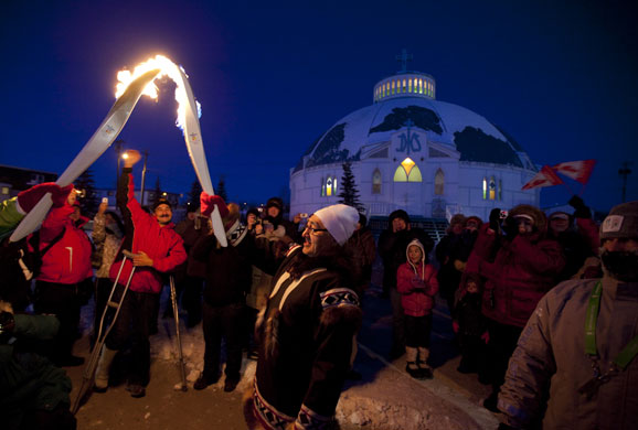 24 hours: People cheer as torchbearer Abel Tingmiak receives the Olympic Flame