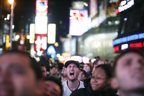 24 hours: New York, US: A fan in Times Square reacts watching the New York Yankees