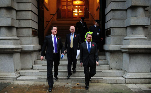 Andrew Parsons Propaganda: Cameron leaves his office in Wesminster with William Hague and Liam Fox