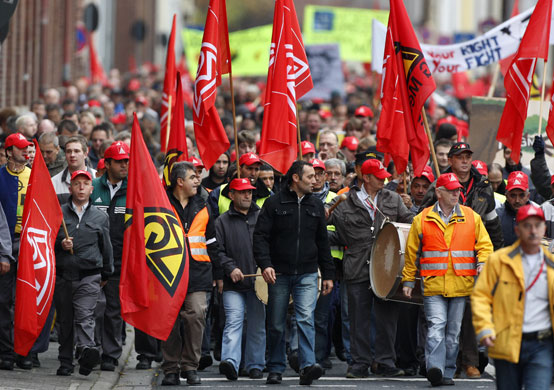 Week in Business: Thousands of Opel workers walk along a street in Ruesselsheim, Germany
