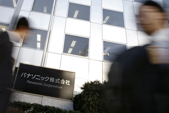 Week in Business: People walk past a Panasonic Corp sign at the company's offices in Tokyo