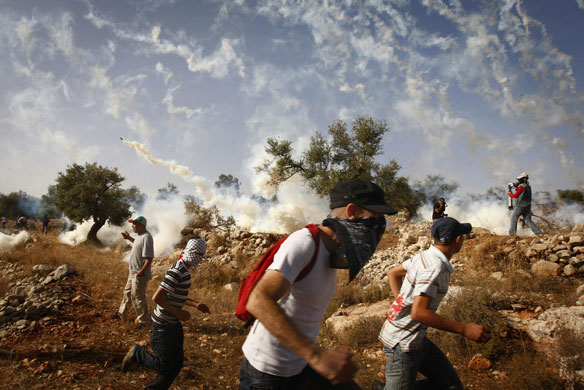 24 Hours in Pics: Demonstrators run away from tear gas canisters fired by Israeli troops