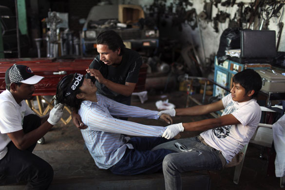 Guatemala morticians: Men prepare their brother for his funeral in Guatemala City
