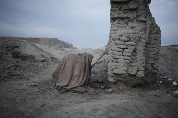 24 hours in pictures: Kabul, Afghanistan: A man smokes opium on the outskirts of the city