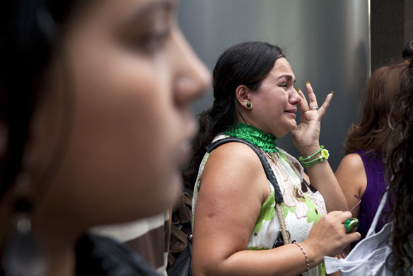 24 hours in pictures: A bank worker reacts outside a branch of Banco Canarias in Caracas