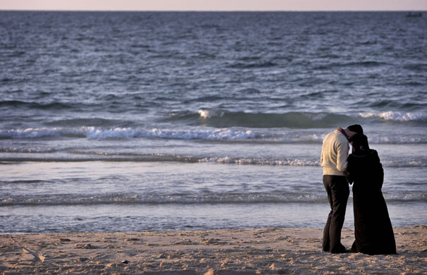 24 hours in pictures: A Palestinian couple stands on the beach at sunset