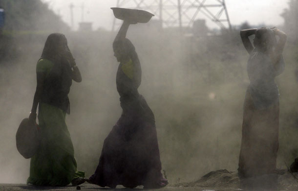 24 hours in pictures: Vapi, India: Women labourers work on a road construction site