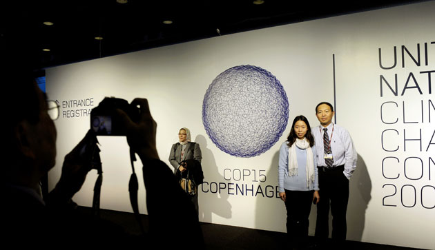 Copenhagen Diary: COP15 Delegates pose beside the COP15 logo  at The Bella Centre
