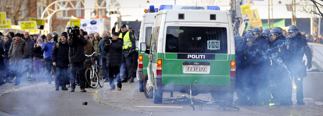 Copenhagen climate summit: Police officers take cover as protestors shoot fireworks at them