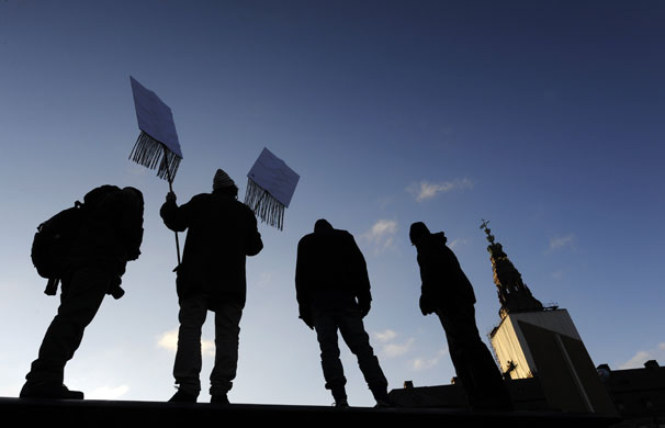 Copenhagen climate summit: Climate change protestors stand on a bus shelter near parliament