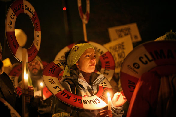Copenhagen climate summit: A protestor holds a candle as she takes part in a march