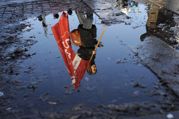 Copenhagen climate summit: A woman reflected in a puddle duirng a demonstration