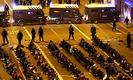 Arrested demonstrators sit on the ground as they are surrounded by police in Copenhagen.