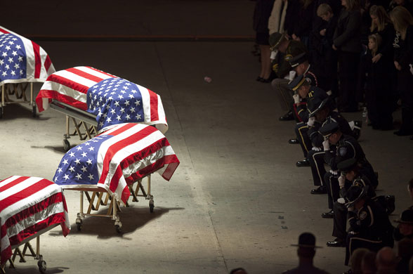 Eyewitness: Police oﬃcers kneel before the coﬃns of US colleagues who were shot dead