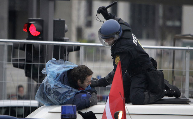 COP15 Reclaim Power: A Danish riot policeman beats a demonstrator outside the Bella Center